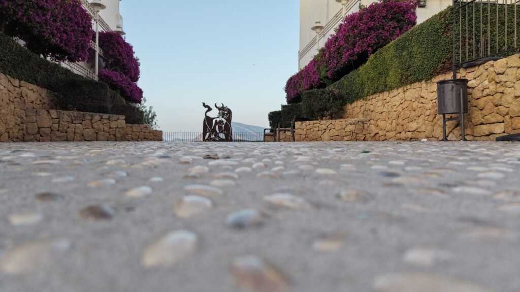 Plaza empedrada del casco antiguo de Altea, con buganvilla y vistas al mar