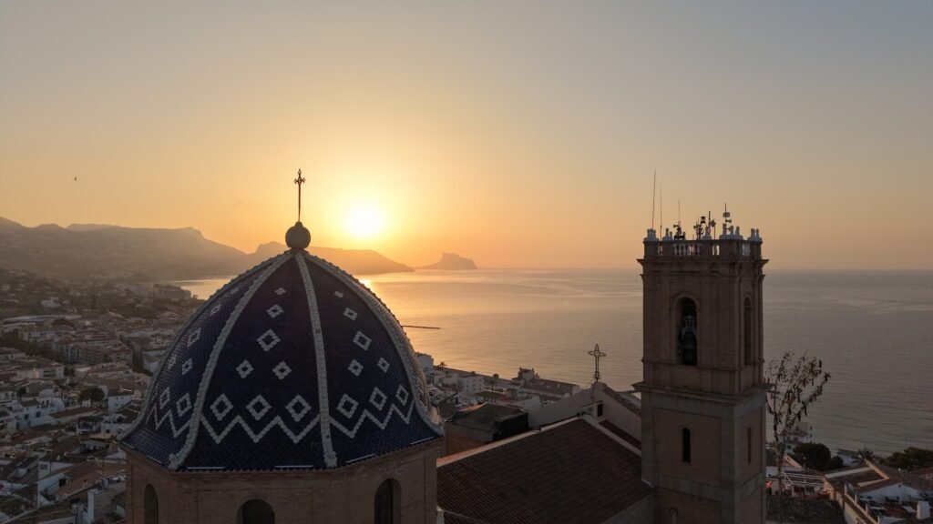 El sol saliendo detras de la cupula de la iglesia de Altea